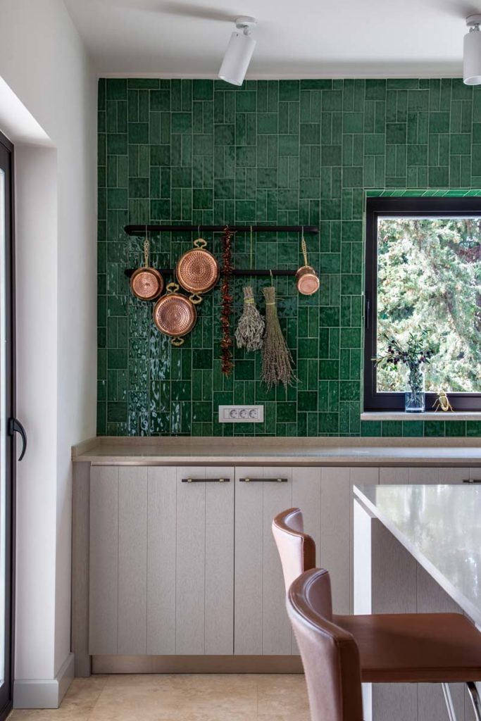 Kitchen accent wall finished in glazed green handmade tile