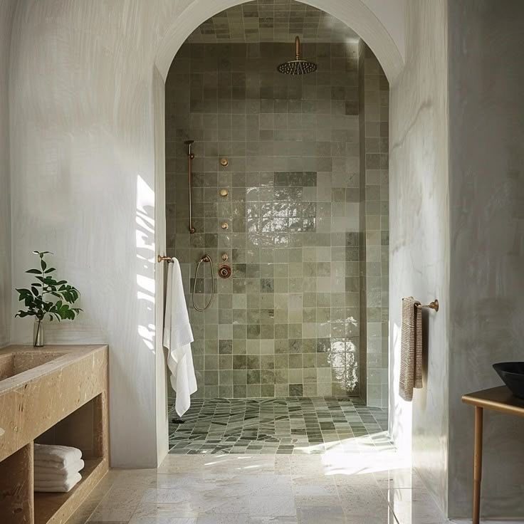 Arched walk-in shower finished in handmade green zellige tile